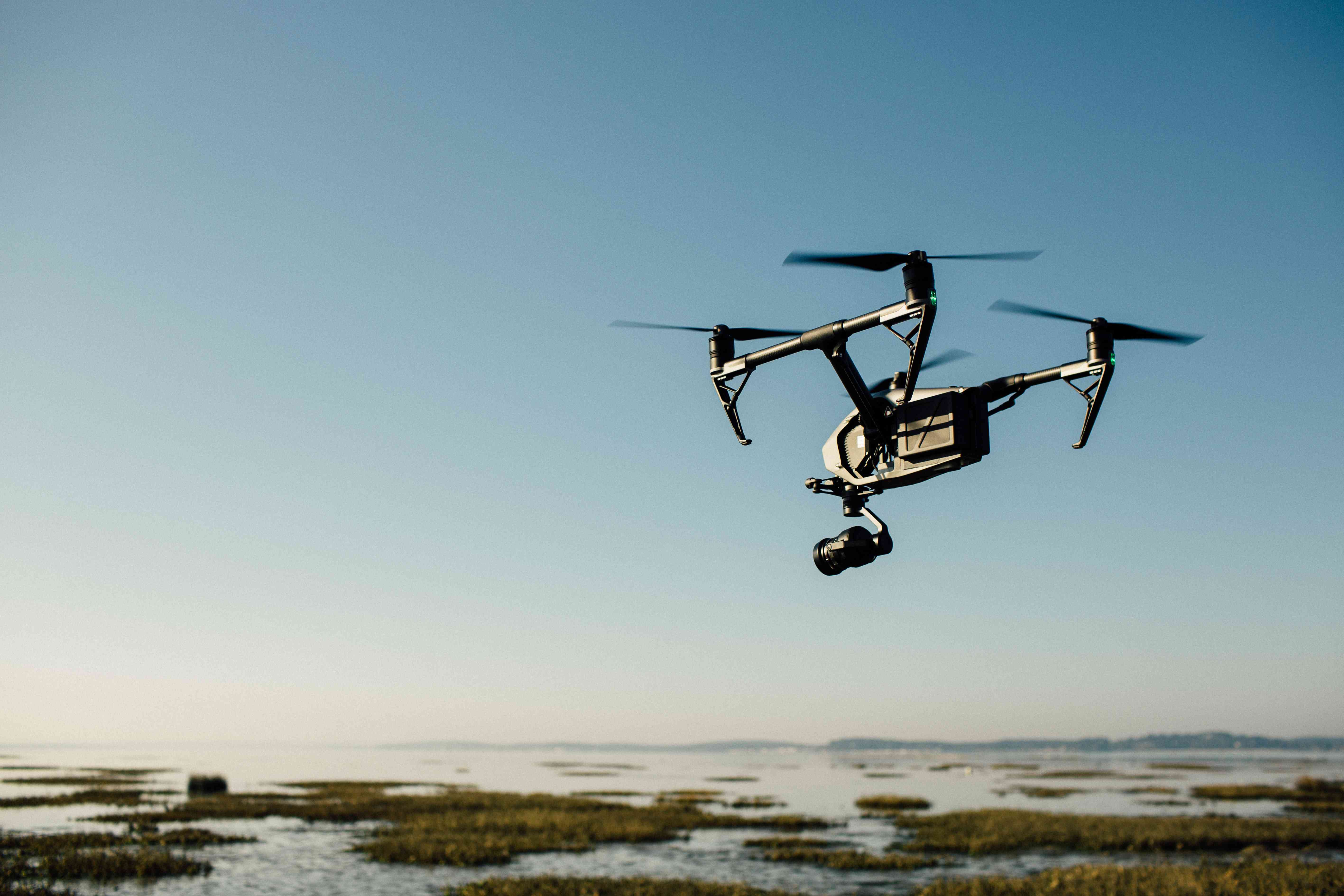 Drone flying over a wetland with a suspended release mechanism